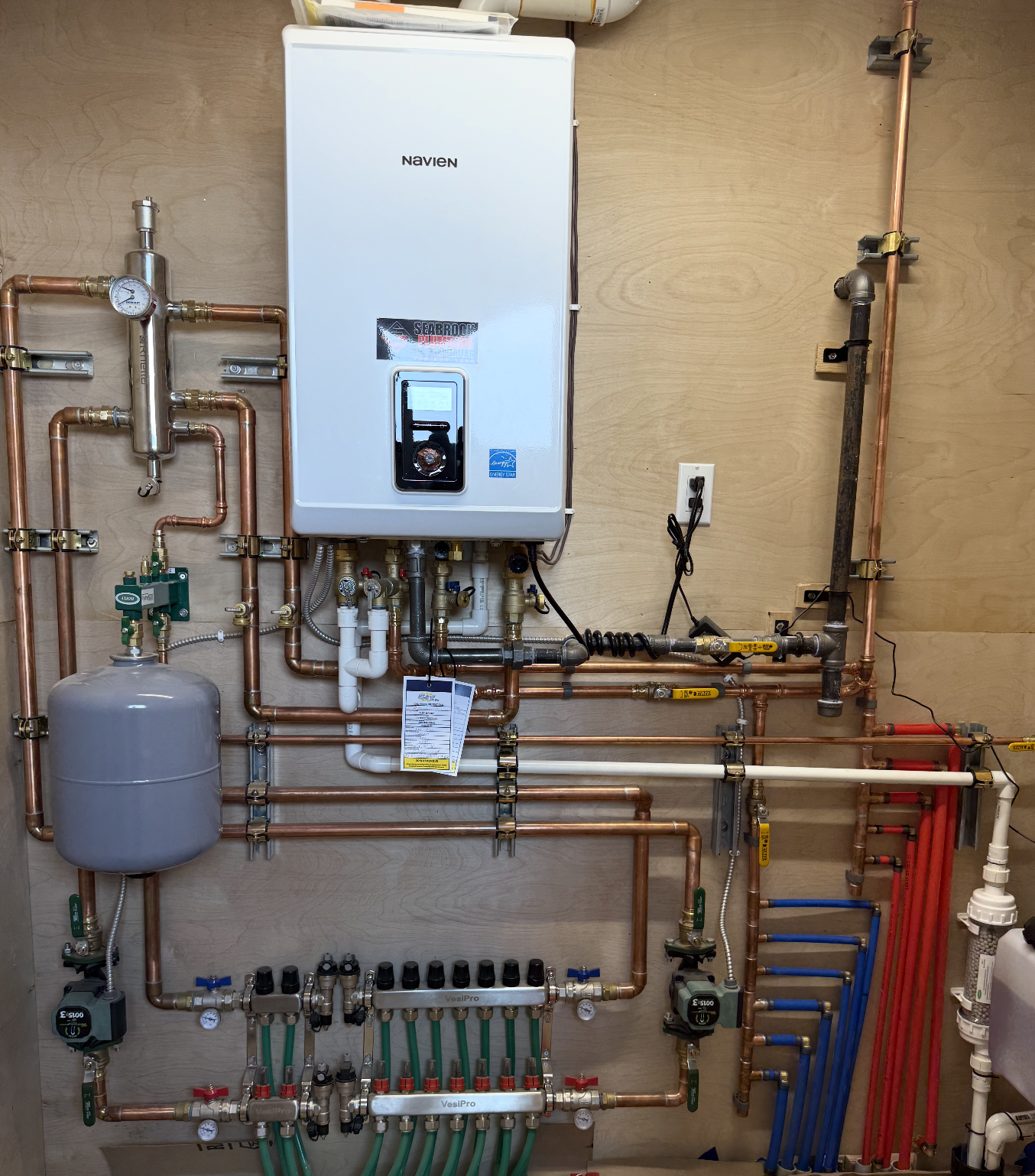 Mechanical room installation with boiler, manifolds, and organized copper piping