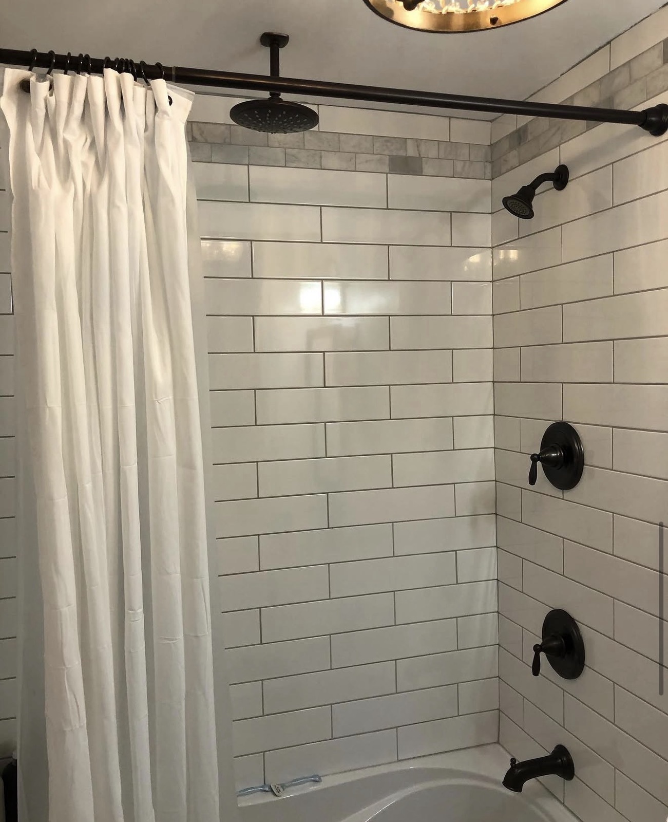 White tile shower with black plumbing fixtures